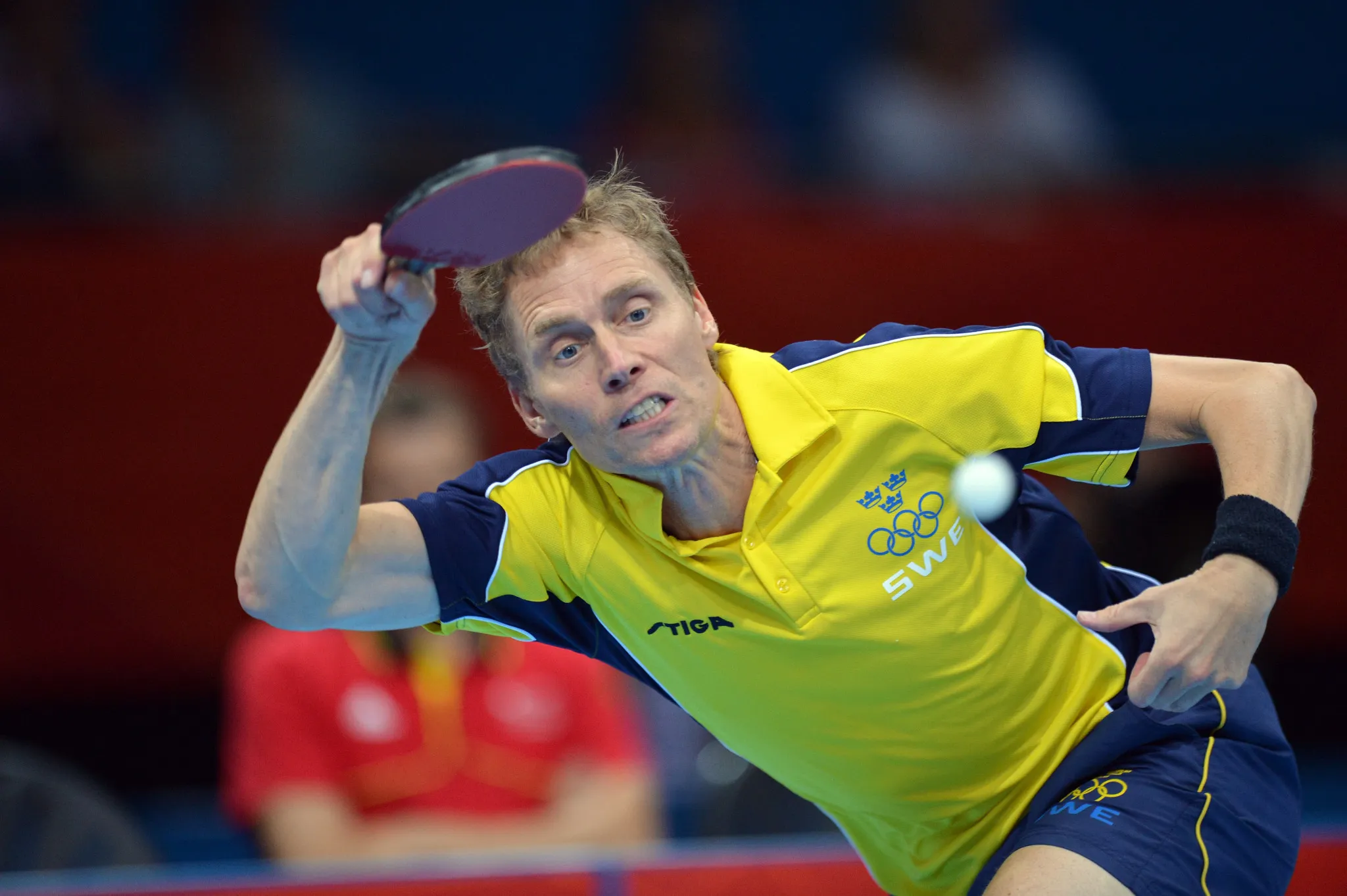 Sweden's Jörgen Persson striking a forehand in his yellow Sweden Olympic jersey at the London 2012 Games