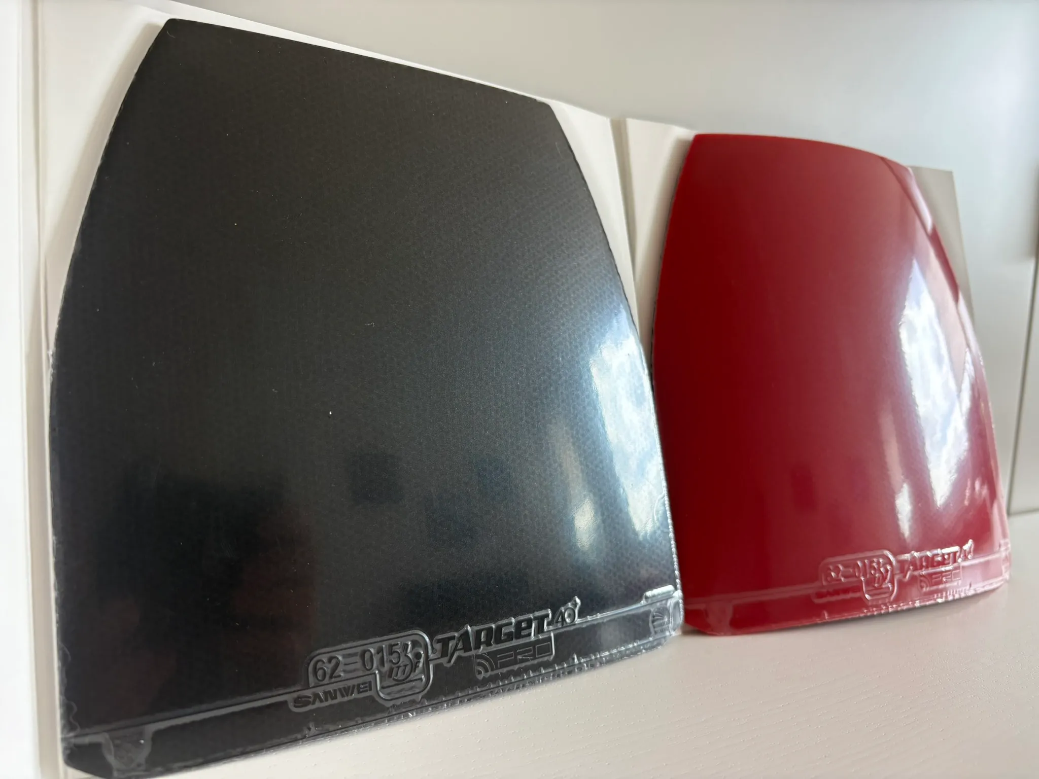 Red and black Target Europe Soft sheets laid flat next to their packaging, showing the curved pre-cut top corners.