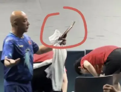 Wang’s coach holding his broken racket
