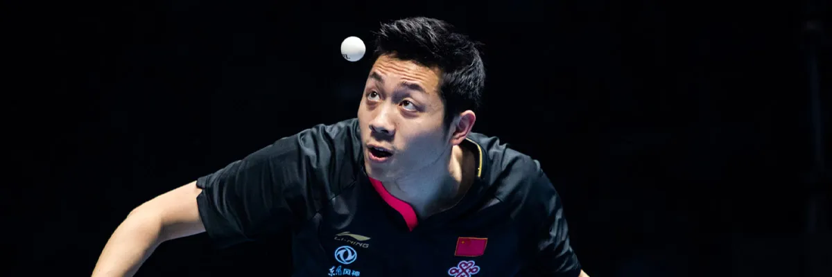 Xu Xin executing a signature penhold backhand away from the table