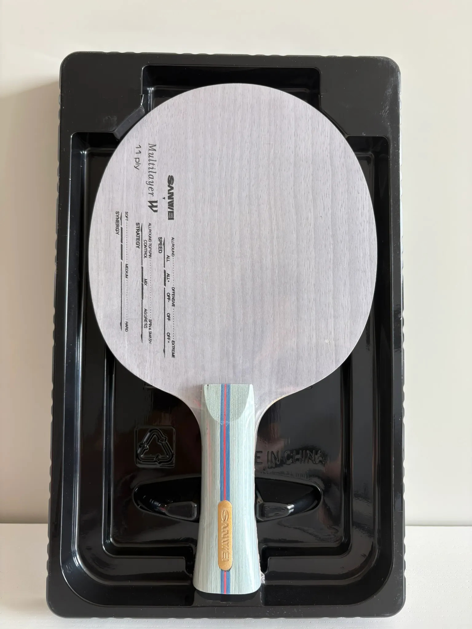 Pale wooden blade seated in a black moulded plastic tray inside the open retail box.
