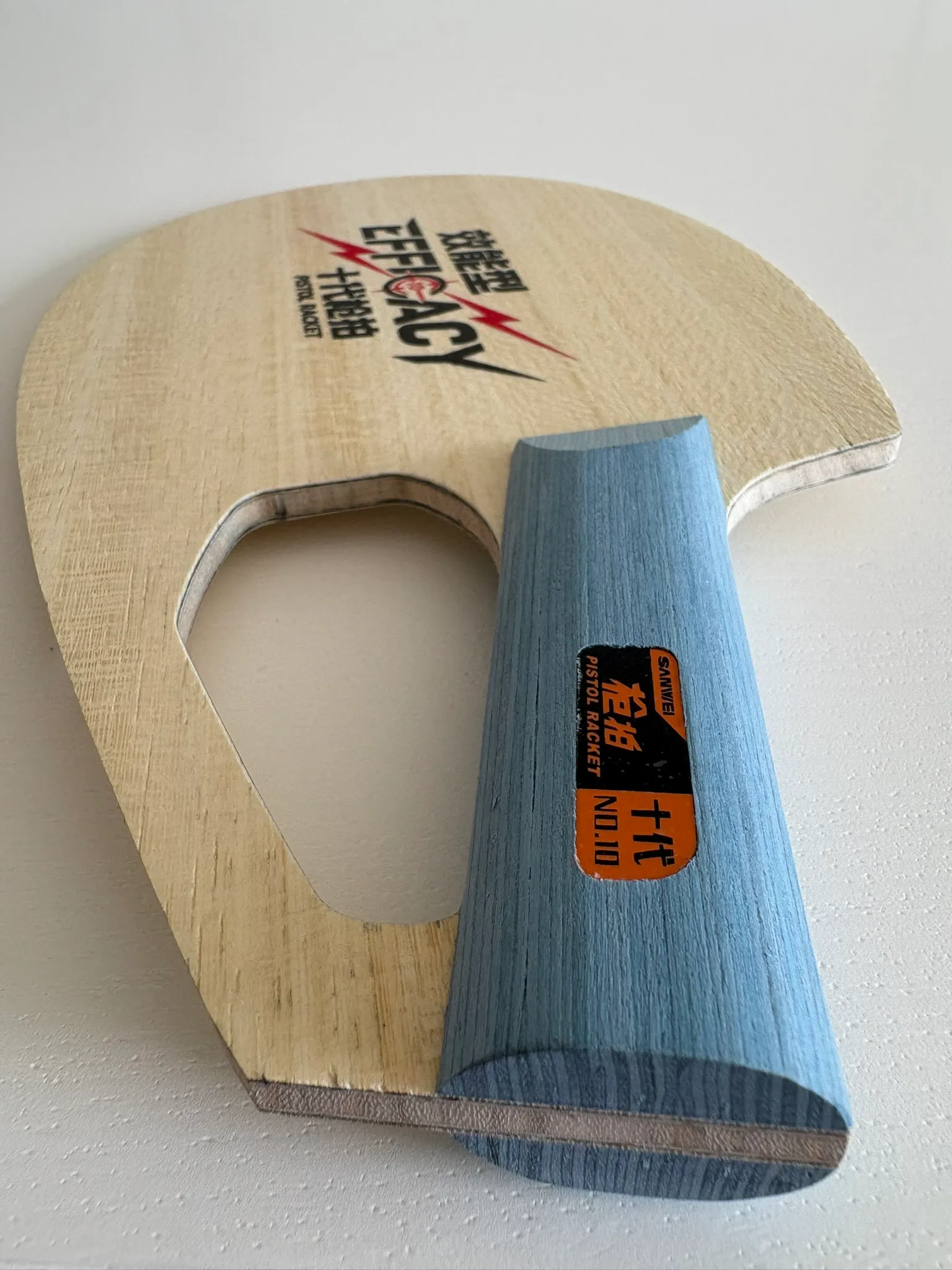 Close-up of the blue pistol handle crossing the blade beside the large finger opening.